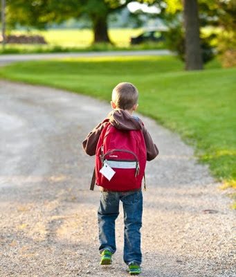 Child wearing backpack going to school