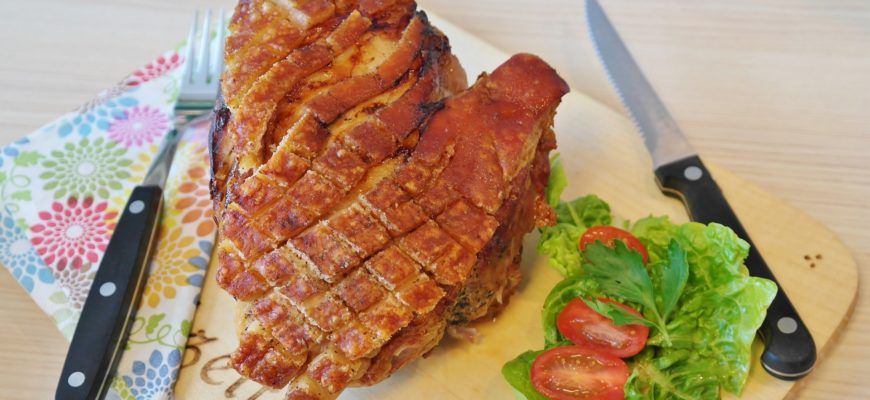 Sliced, brined pork roast and veggies on a cutting board