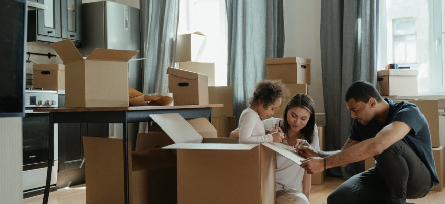 Family unpacking moving boxes