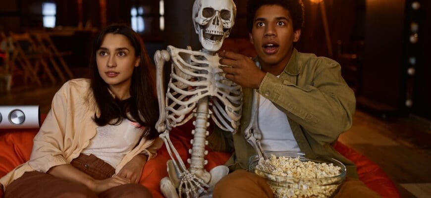 Funny,Couple,And,Skeleton,Watching,Studio,Projector