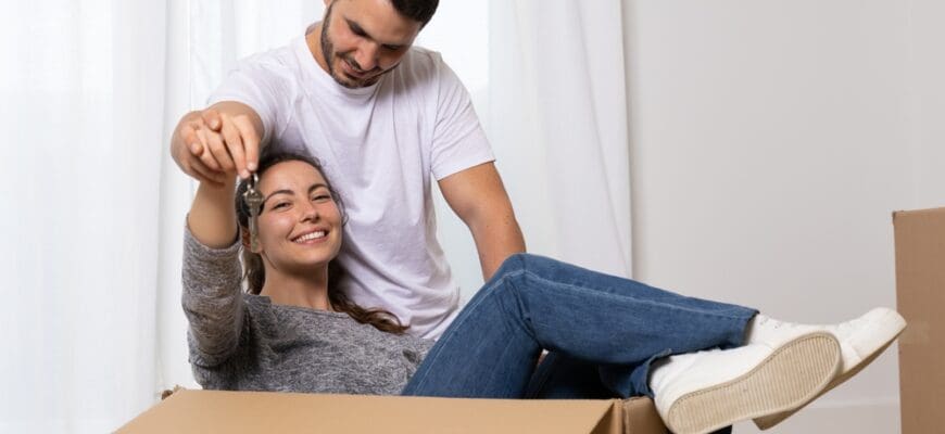 Happy,Young,Couple,Just,Married,Celebrating,Moving,Day,With,Cardboard