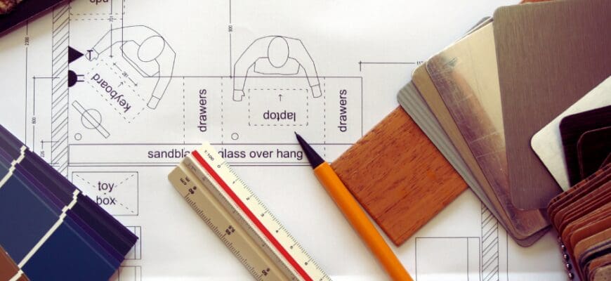 Renovation blueprints, paint swatches, and various measuring tools on a desk